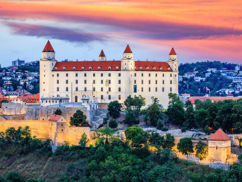 A photo of the castle at sunset. The sky is orange and pink above it